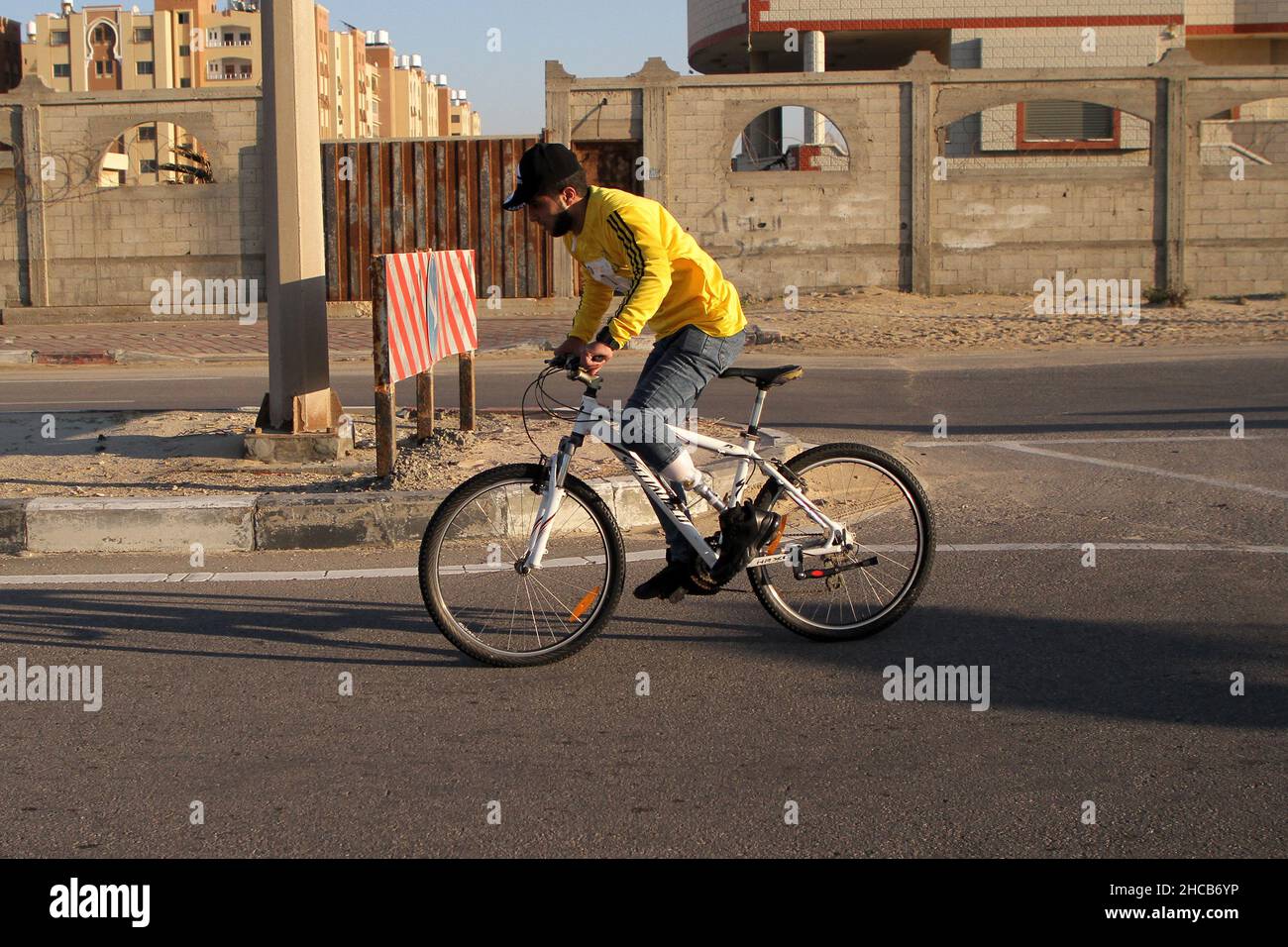 Gaza. 26th Dic 2021. Un palestinese con disabilità fisiche partecipa a una gara ciclistica organizzata dalla Federazione Palestinese in bicicletta nel mezzo della striscia di Gaza, il 26 dicembre 2021. Credit: Rizek Abdeljawad/Xinhua/Alamy Live News Foto Stock