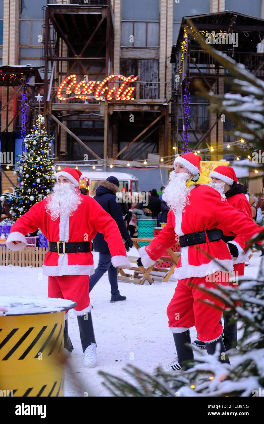 Minsk, Bielorussia, 25 dicembre 2021: Tre Babbo Natale alla fiera di Capodanno divertire le persone. Foto Stock