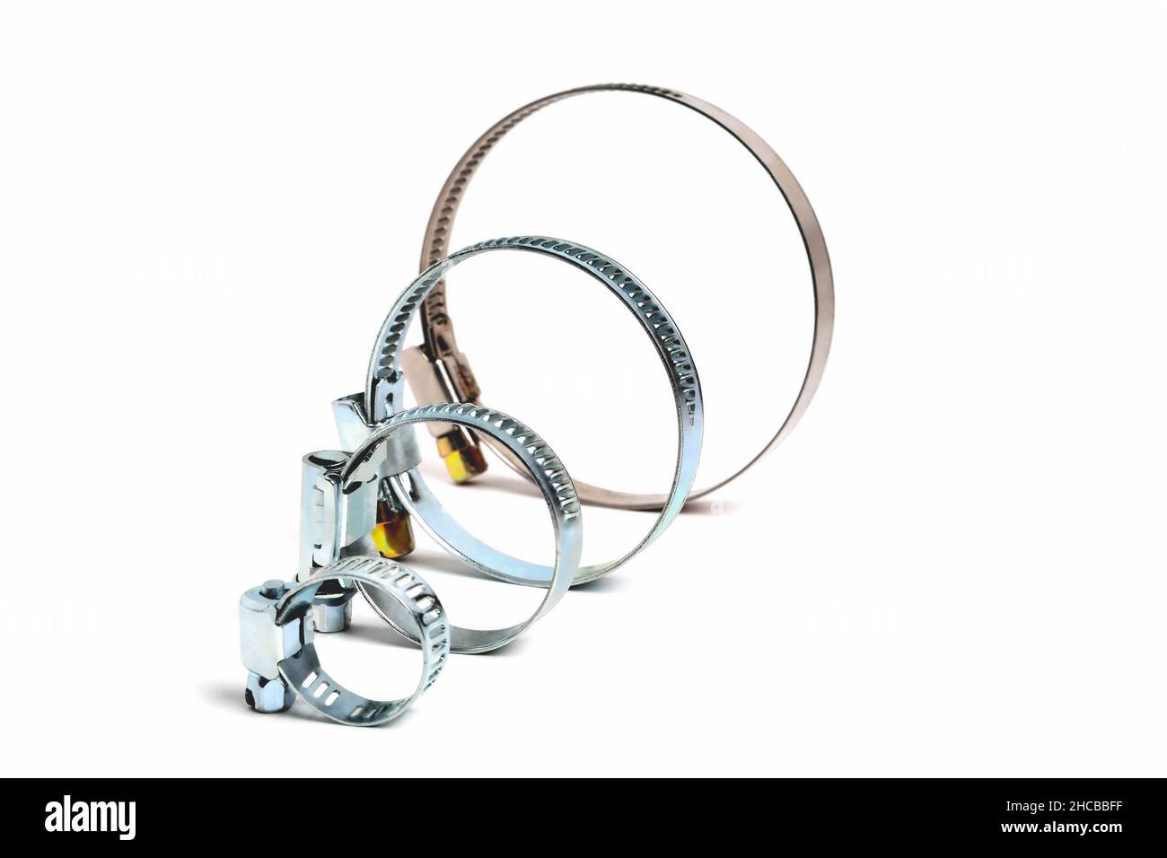 clip per tubo flessibile, morsetti di serraggio a vite senza fine rotondi su sfondo bianco, primo piano, messa a fuoco selettiva Foto Stock