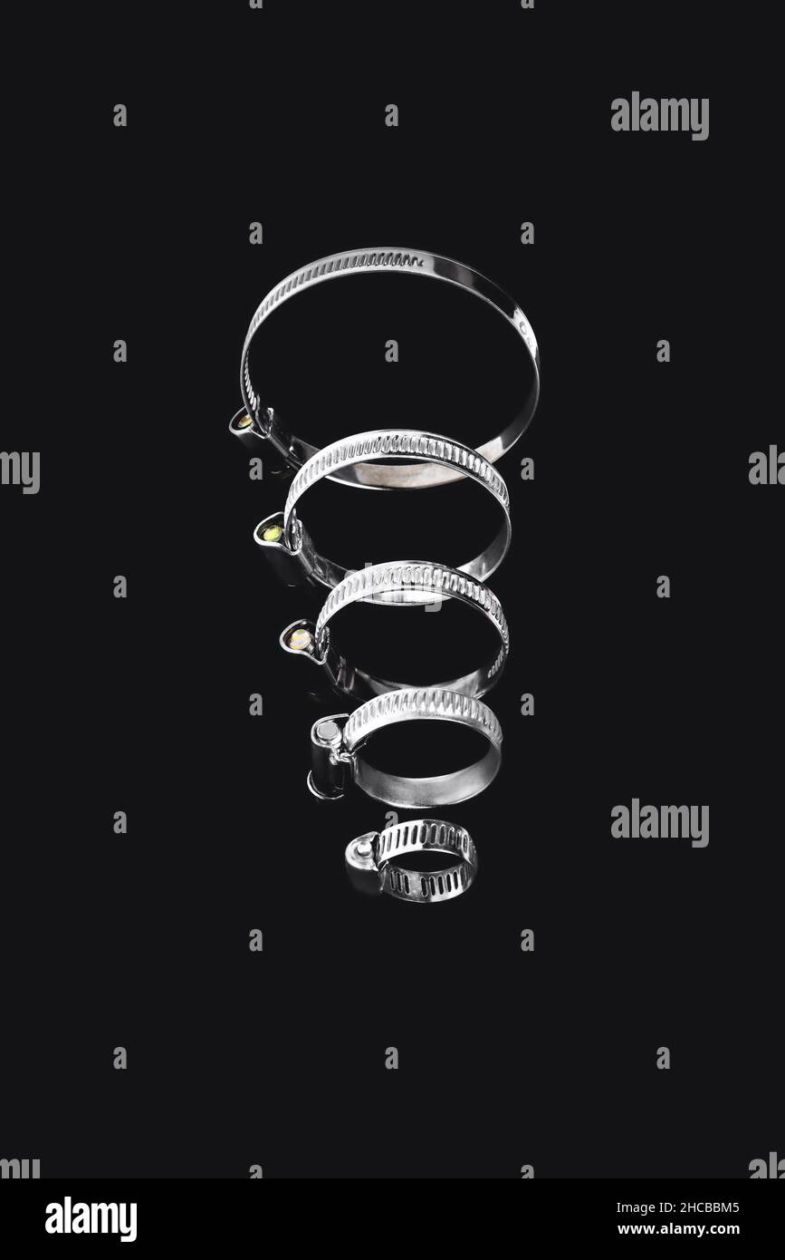 fascetta stringitubo, fascetta di serraggio a vite senza fine rotonda su sfondo nero, primo piano, messa a fuoco selettiva Foto Stock
