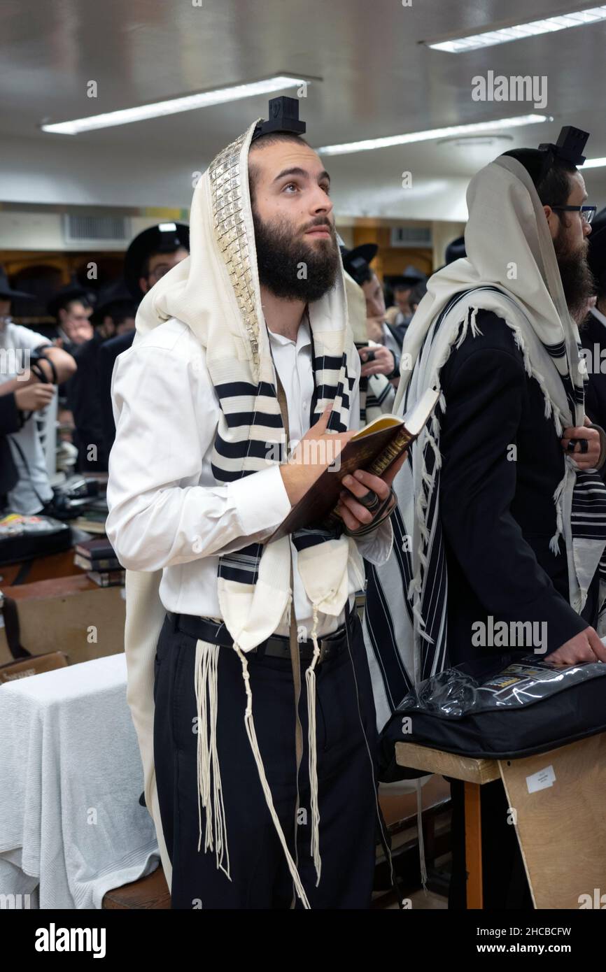 Un ebreo ortodosso in preghiera sembra guardare a Dio. In una sinagoga a Brooklyn, New York. Foto Stock