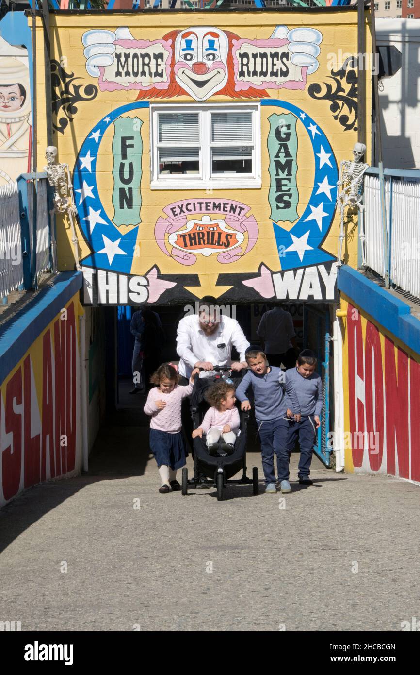 Una famiglia ebrea ortodossa si avvicina al lungomare dell'Isola di Coney durante le vacanze Sukkot, dove è obbligatorio per Buon divertimento. A Brooklyn, New York Foto Stock