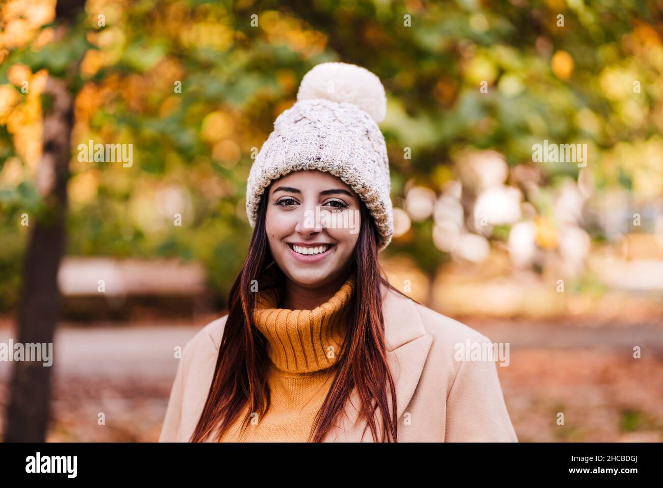 Giovane donna che indossa un cappello a maglia al parco autunnale Foto Stock