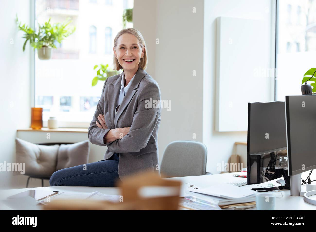 Donna d'affari premurosa con documenti seduti alla scrivania Foto Stock