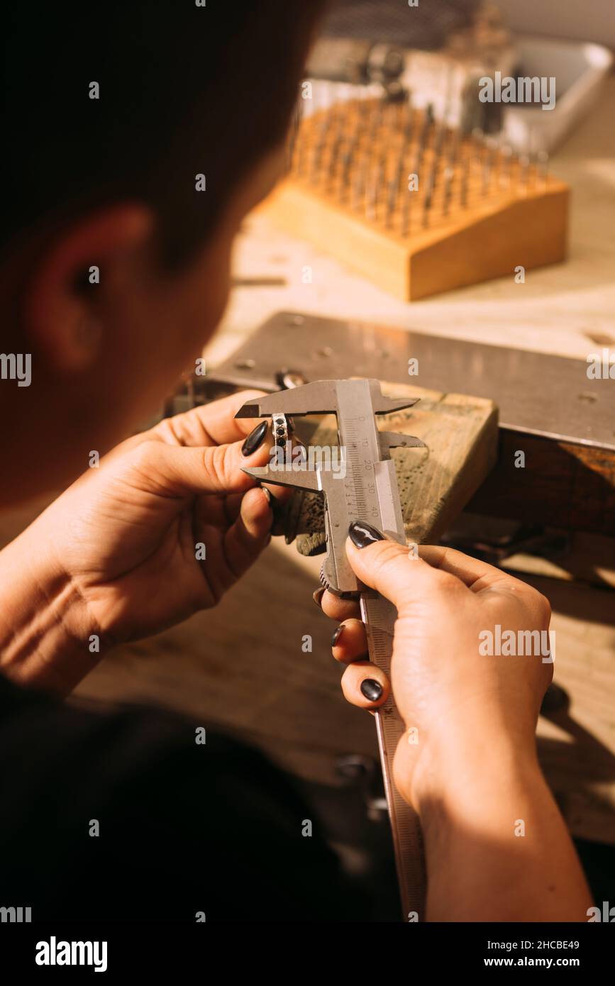Anello di carving per gioielliere femmina con utensile in officina Foto Stock