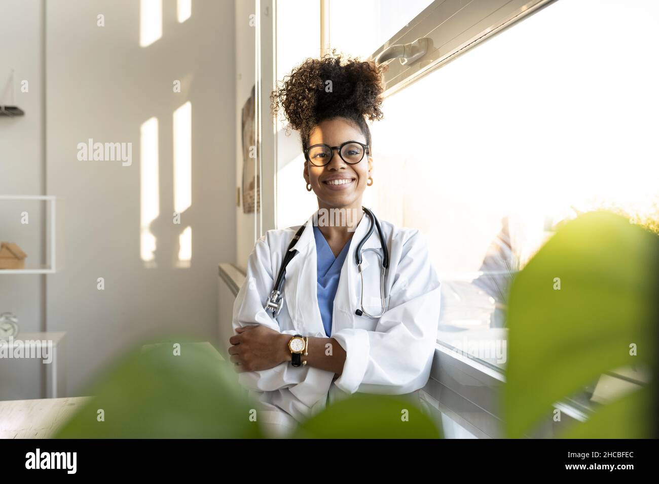 Medico premuroso femmina che guarda fuori dalla finestra a casa Foto Stock