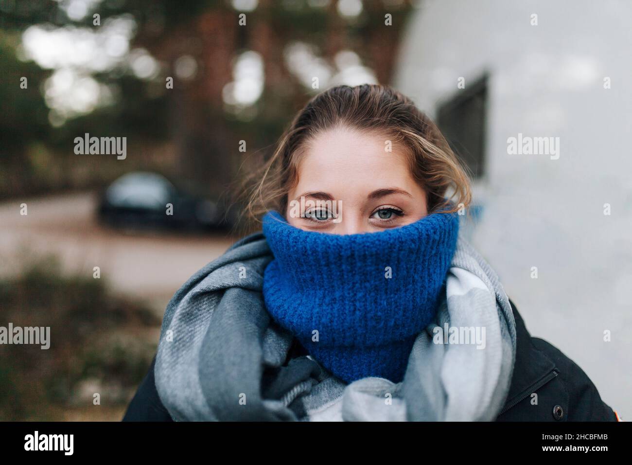 Il volto della donna è ricoperto da un maglione di dolcevita blu Foto Stock