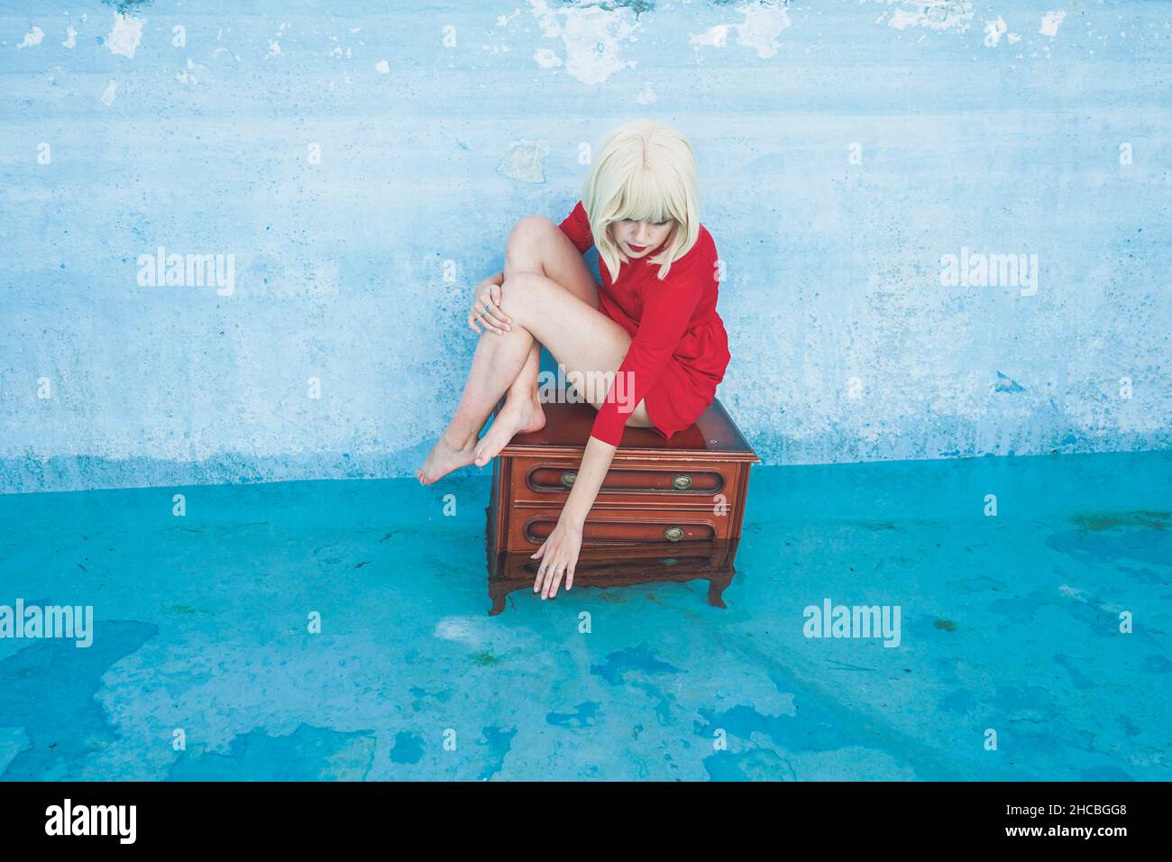 Donna su antico dresser che raggiunge l'acqua in piscina Foto Stock