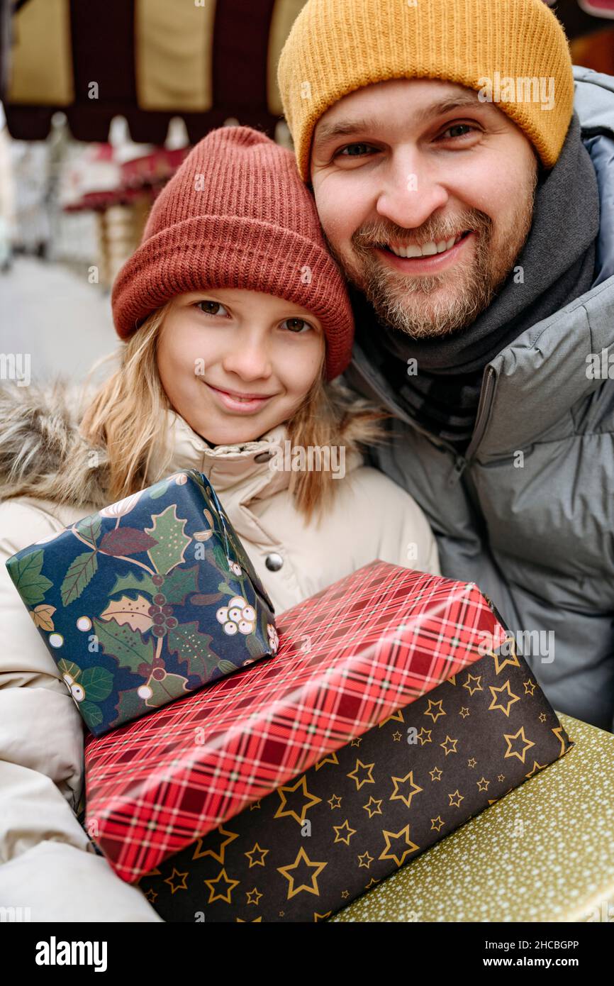 Padre e figlia che tengono regali di Natale di fronte al negozio Foto Stock