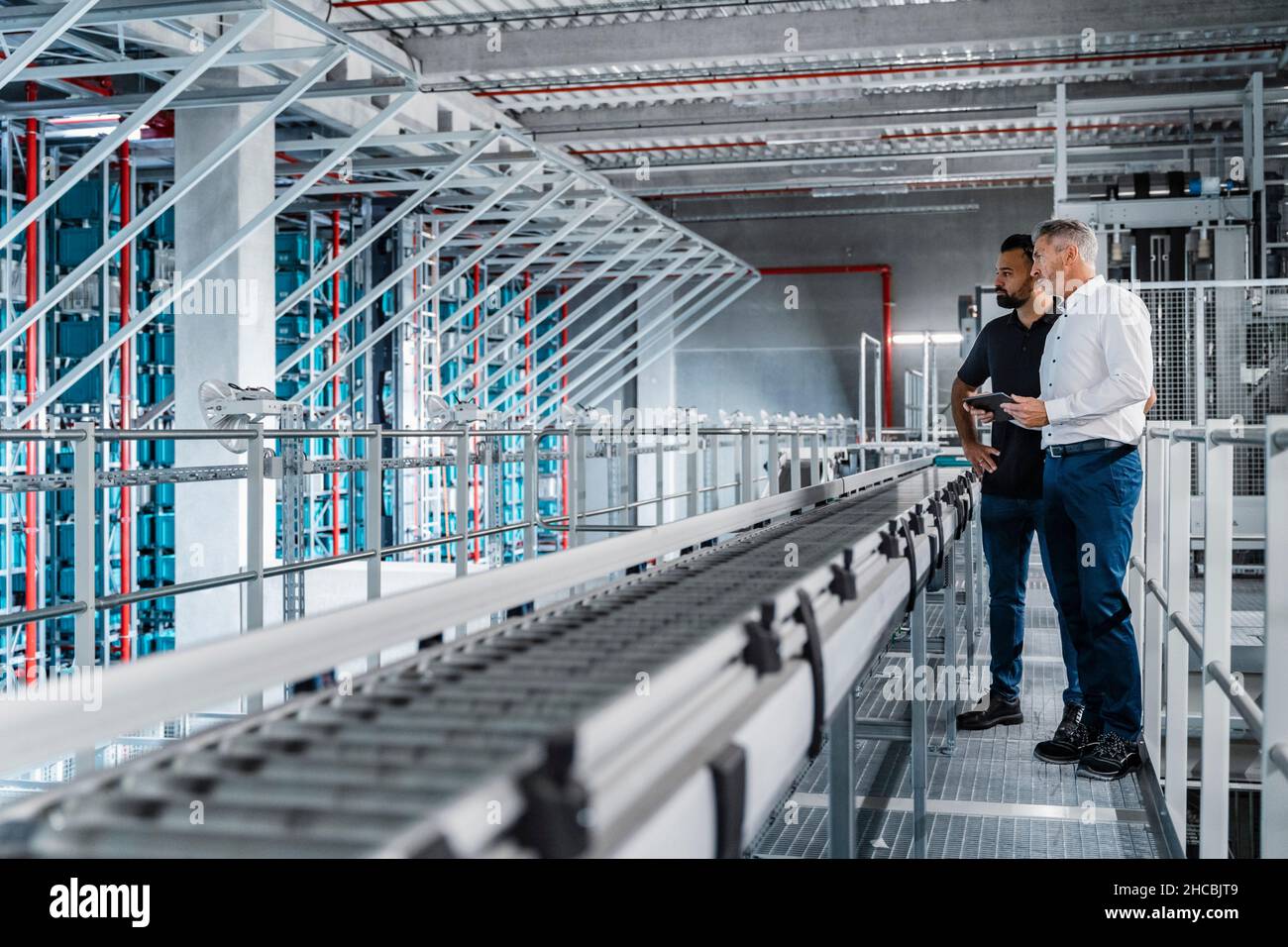 Uomo d'affari con il warehouse manager che detiene tablet PC nel settore Foto Stock