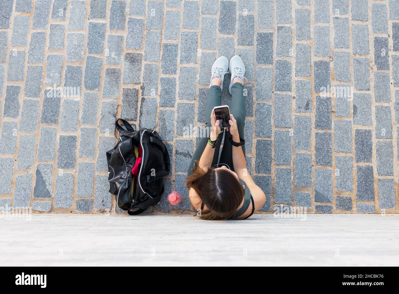 Giovane atleta che utilizza il telefono cellulare sul sentiero Foto Stock
