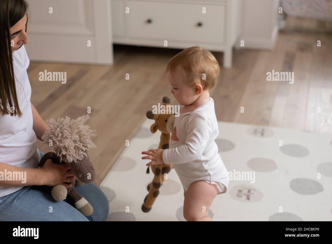 Bambina e madre che giocano con giocattoli imbottiti a casa Foto Stock