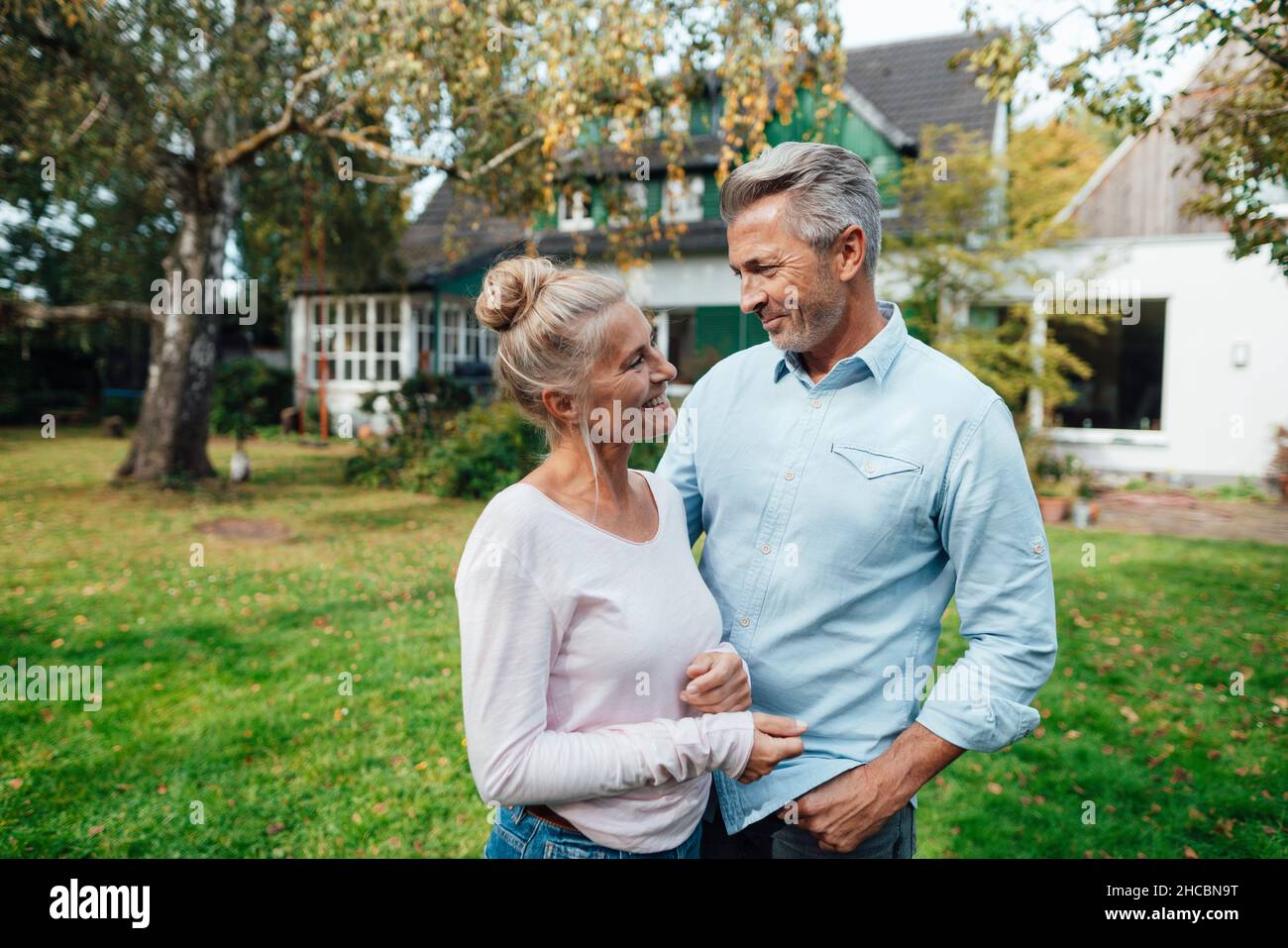 Donna sorridente che ricopre il volto dell'uomo con la rete da pesca a farfalla sul cortile Foto Stock