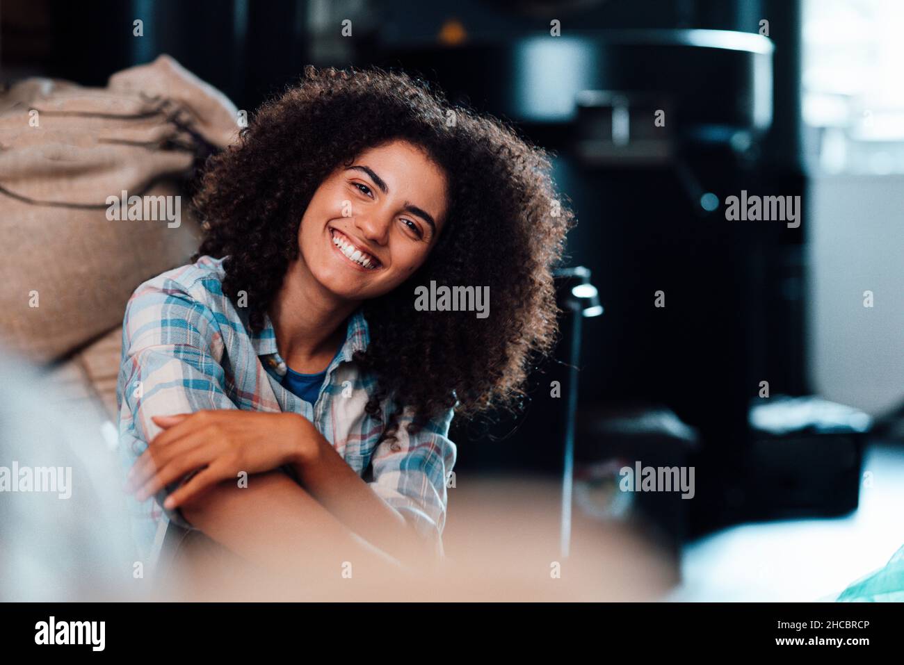 Donna d'affari felice vicino le borse di caffè in roadery Foto Stock