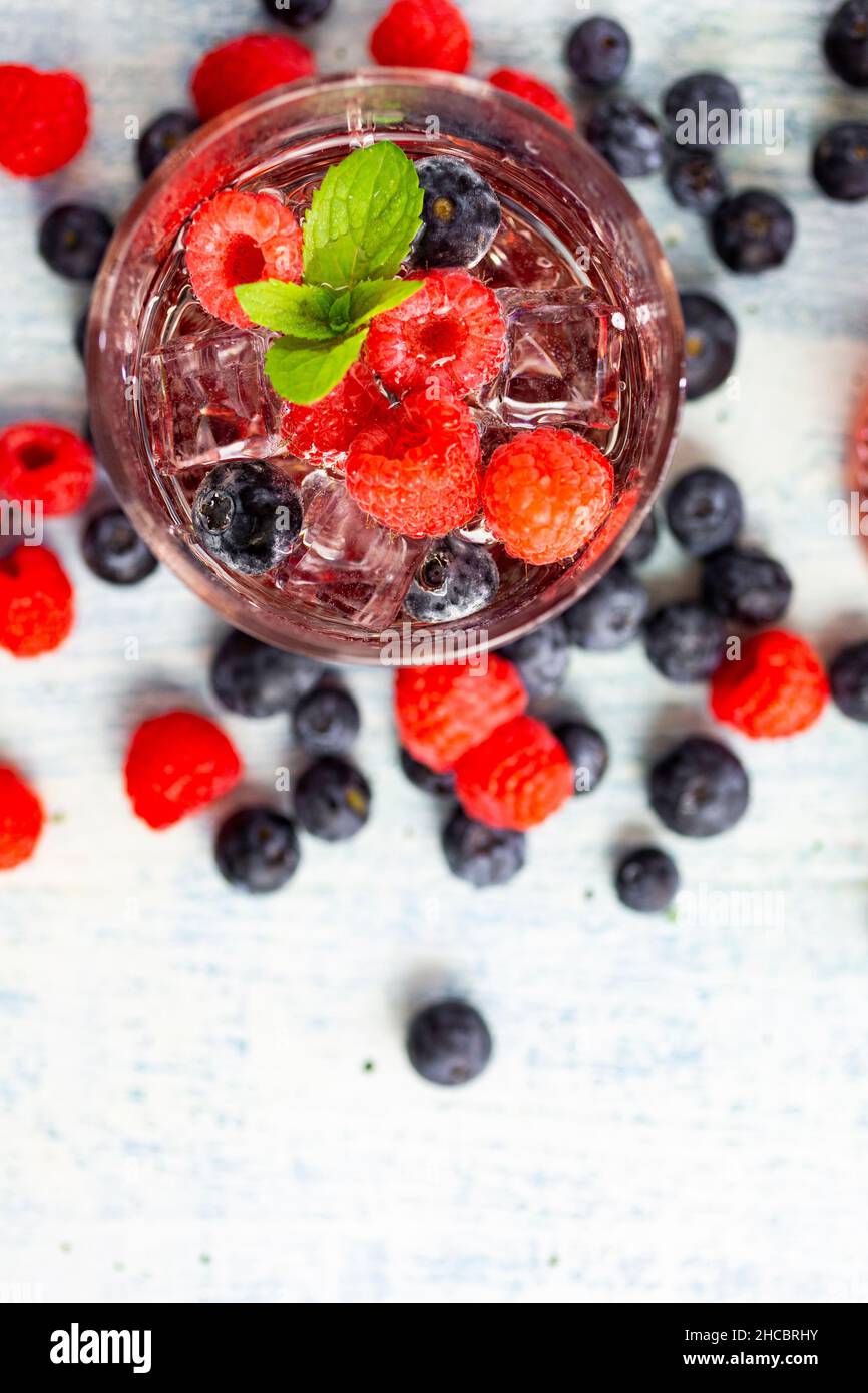 Due bicchieri di gin tonic su un vassoio seduti su un tavolo da giardino  con sole forte in background Foto stock - Alamy