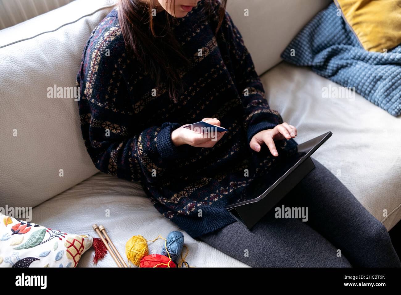 Donna con carta di credito che usa un tablet PC a casa Foto Stock