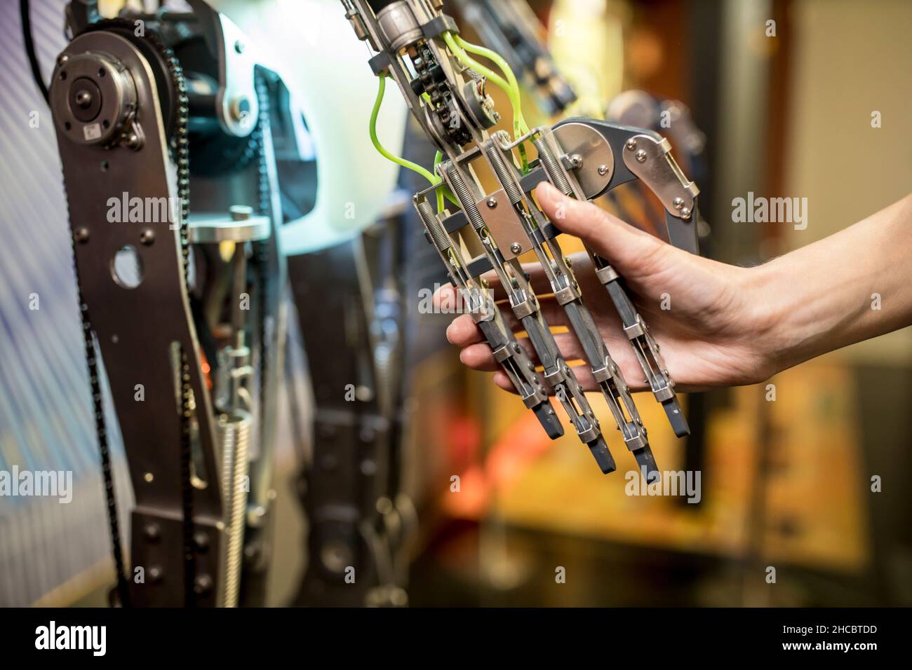Ingegnere che fa la stretta di mano con il braccio robotico in officina Foto Stock