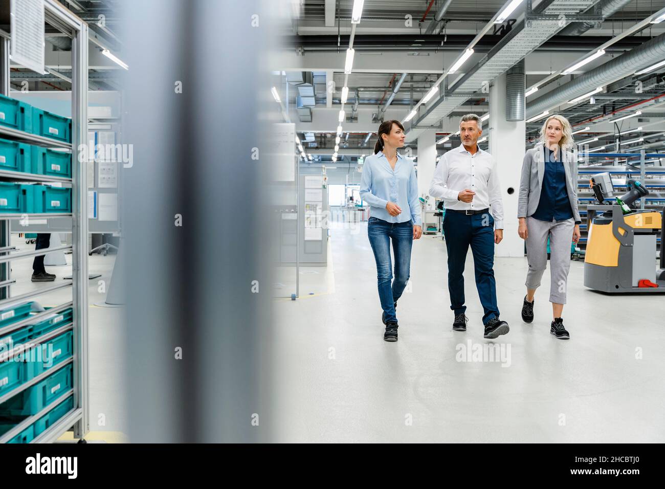 Uomo d'affari con colleghi che ispezionano l'industria automatizzata Foto Stock