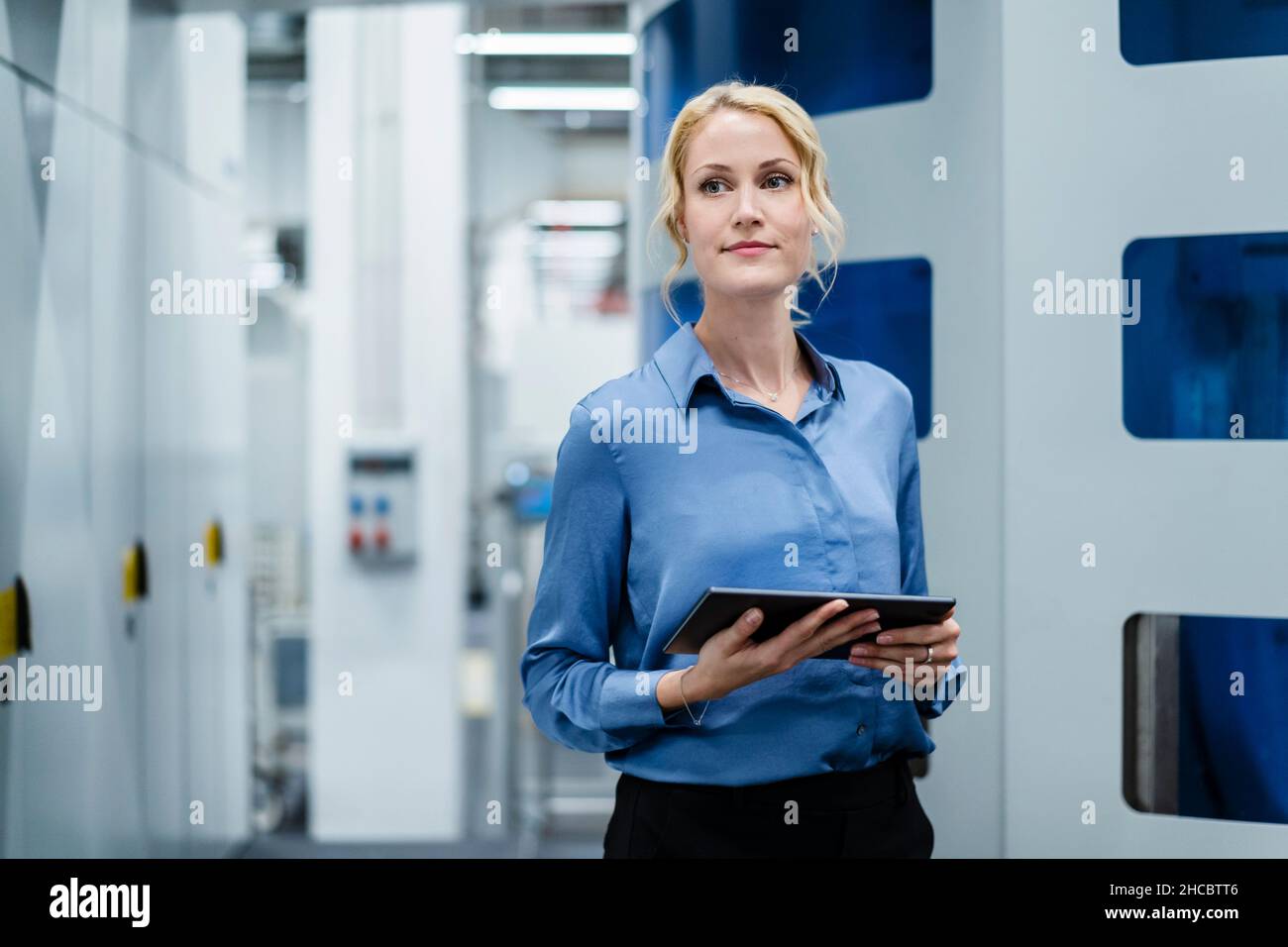 Donna d'affari con tablet PC nell'industria elettrica Foto Stock