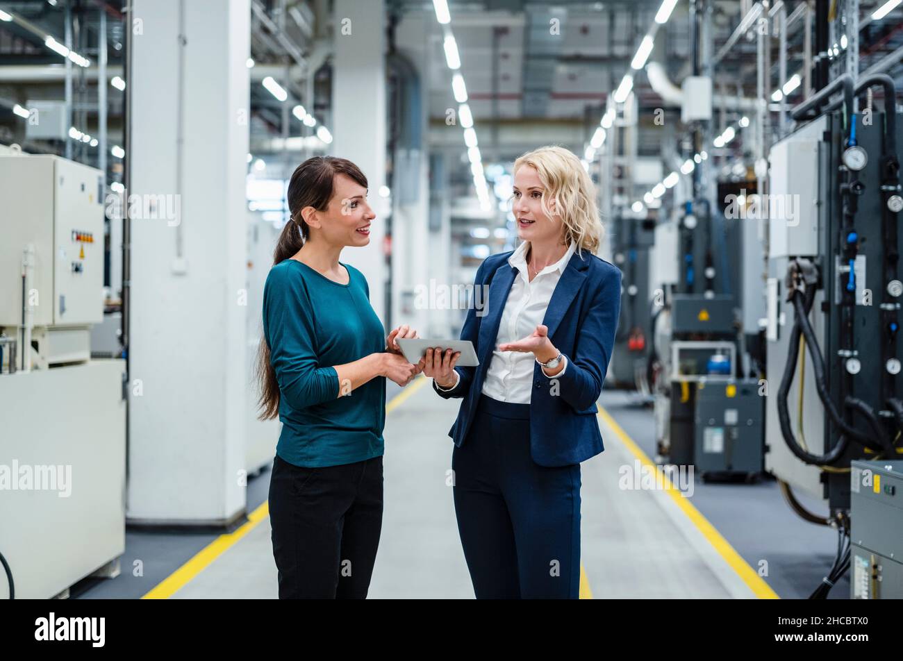 Donne d'affari che hanno discusso all'industria elettrica Foto Stock