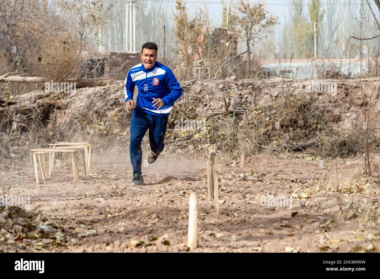 Urumqi, la regione autonoma cinese di Xinjiang Uygur. 13th Nov 2021. Nurmemet Sherep si allena in un campo di grano nella contea di Shufu della prefettura di Kashgar, regione autonoma di Xinjiang Uygur della Cina nord-occidentale, 13 novembre 2021. PER ANDARE CON: 'Profilo: Dai campi di mais ai campi di calcio: L'autodidatta stella di calcio Xinjiang' Credit: Ma Kai/Xinhua/Alamy Live News Foto Stock