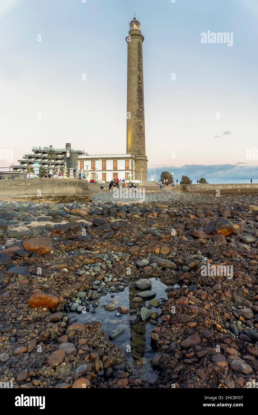 Faro sulla costa rocciosa durante il tramonto a Maspalomas, Gran Canaria, Spagna Foto Stock