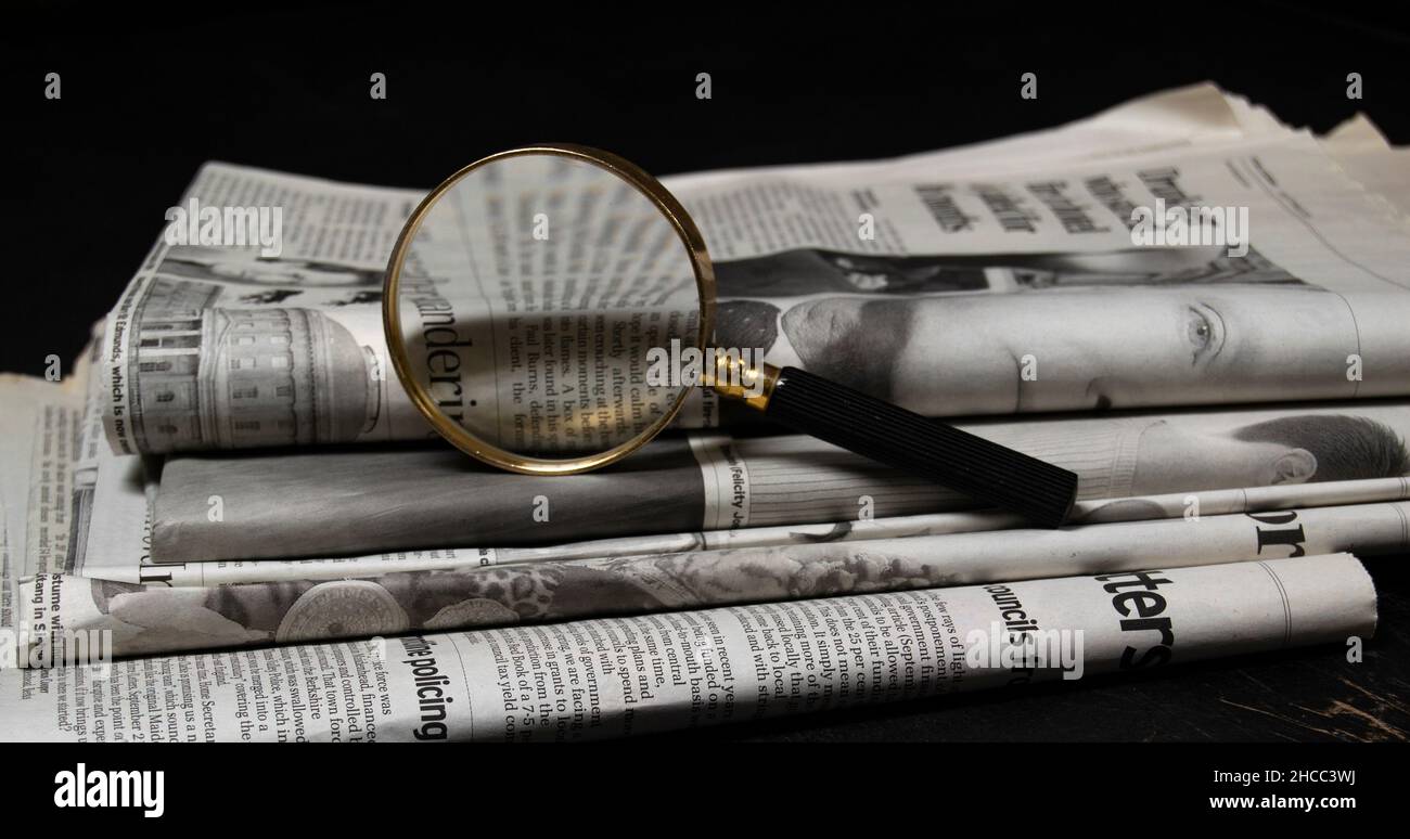 27-12-2021, Roma, Italia. Lente d'ingrandimento e giornali. Concetto di verifica dei fatti, ricerca detettiva, controllo del fack Foto Stock