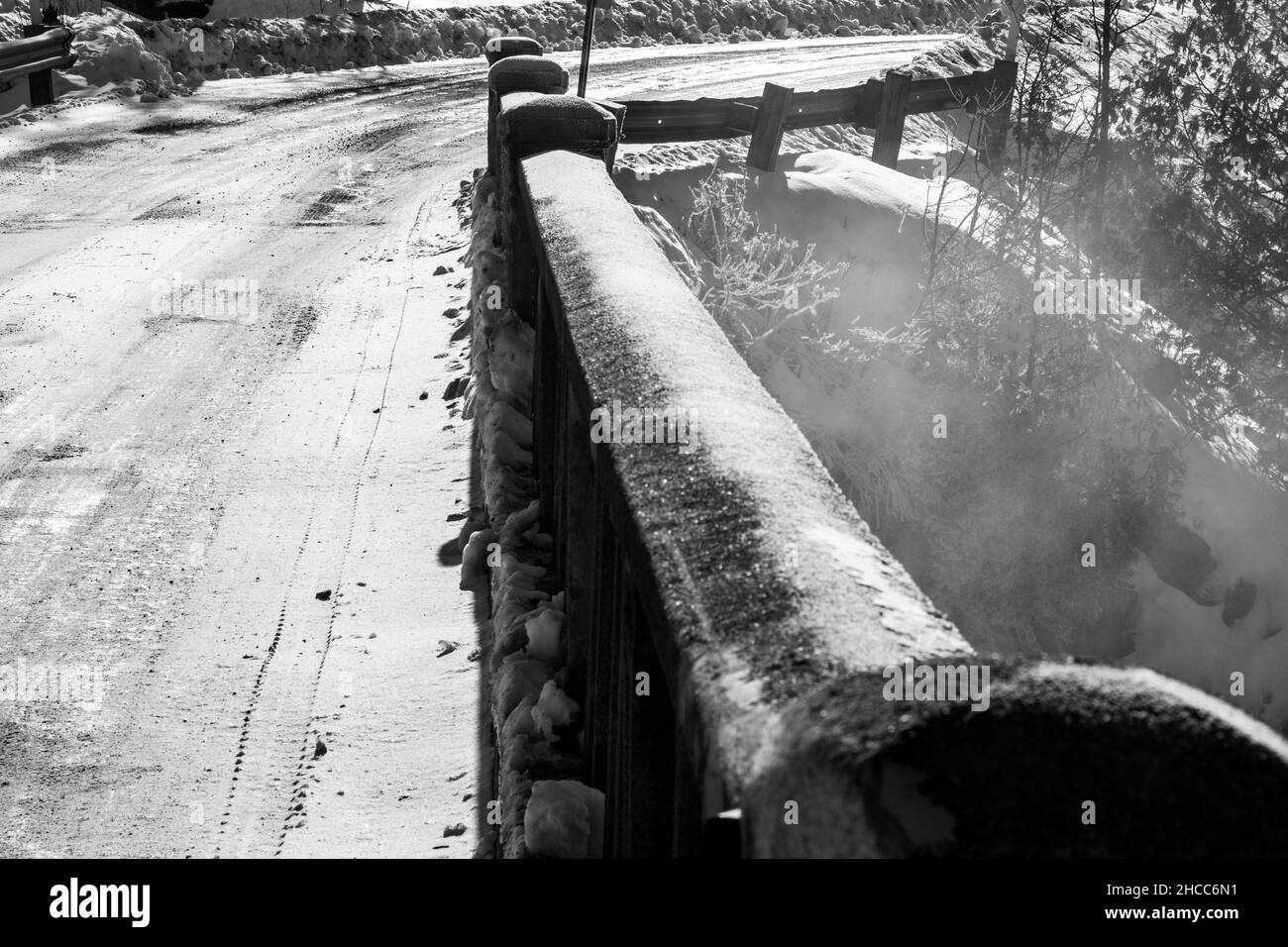 Scala di grigi di un vecchio ponte di cemento sul fiume Foto Stock