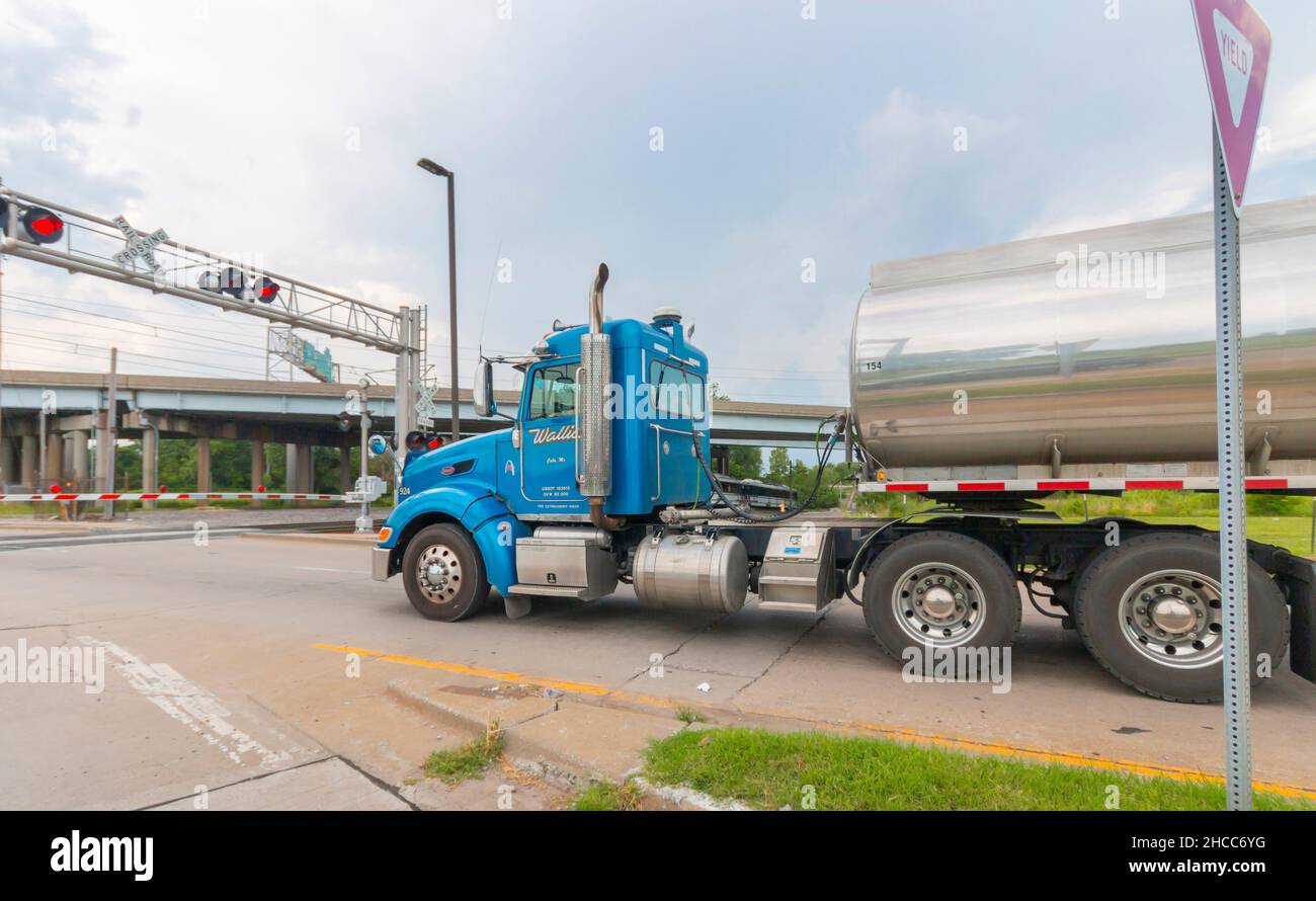 Il grande camion della cisterna si fermò all'incrocio ferroviario americano Foto Stock