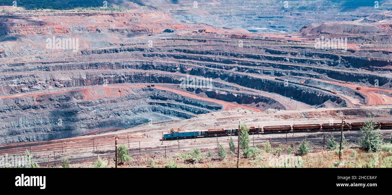 Estrazione del minerale di ferro nella cava dell'impianto di estrazione e lavorazione Mikhailovsky, un treno viaggia all'interno della cava Foto Stock