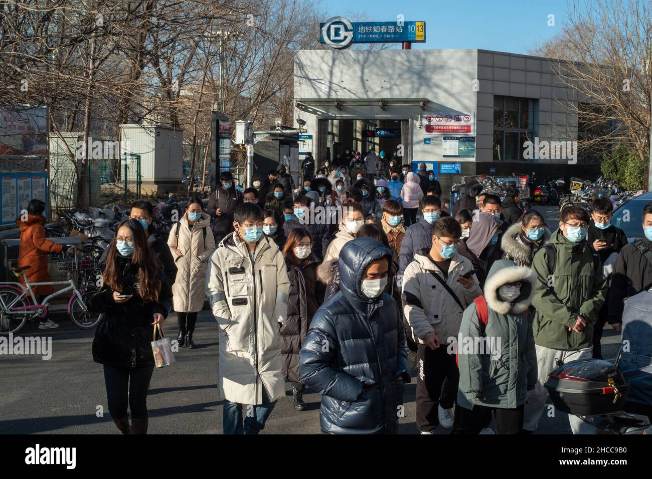 I pendolari del mattino escono dall'uscita della metropolitana a Zhongguancun, centro tecnologico di Pechino, Cina. 27-dic-2021 Foto Stock