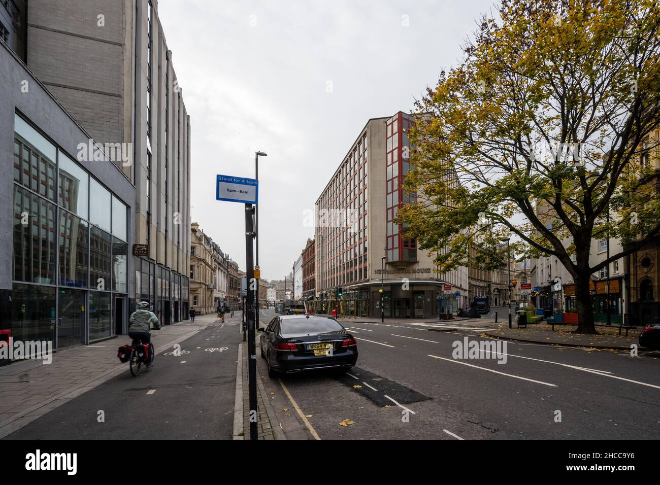 Un ciclista passa davanti agli edifici di uffici su una pista ciclabile protetta lungo Baldwin Street nel centro di Bristol. Foto Stock