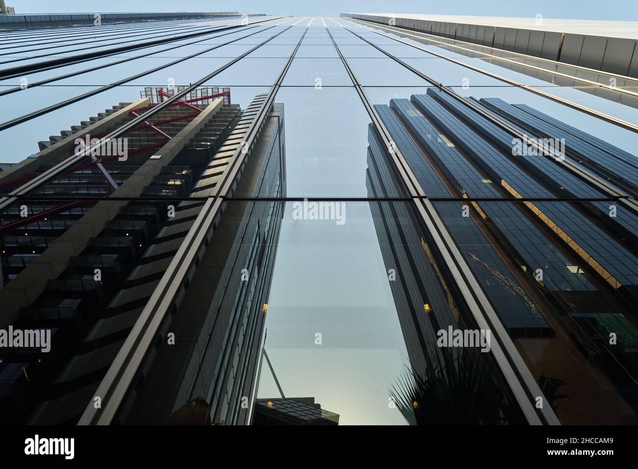 Un alto edificio in vetro ad angolo basso con riflessi di altri edifici Foto Stock