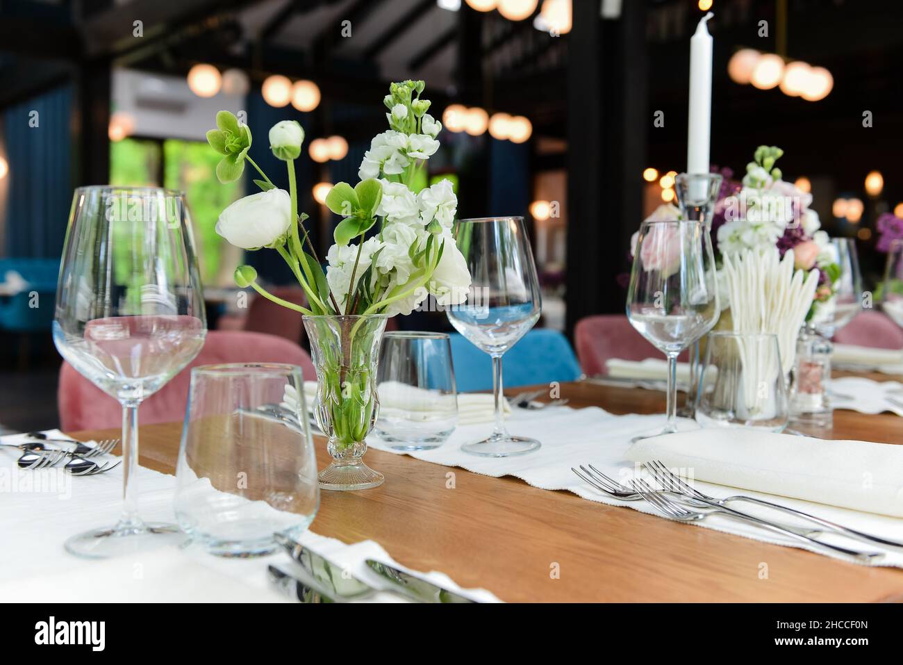 Primo piano di fiori bianchi decorativi in vasi e altri ambienti su un tavolo di legno in un caffè Foto Stock