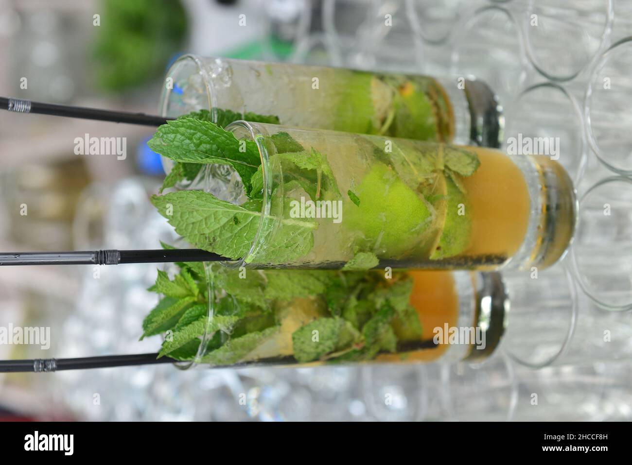 Shot verticale di tre bicchieri di cocktail freschi con menta e lime con una paglia Foto Stock