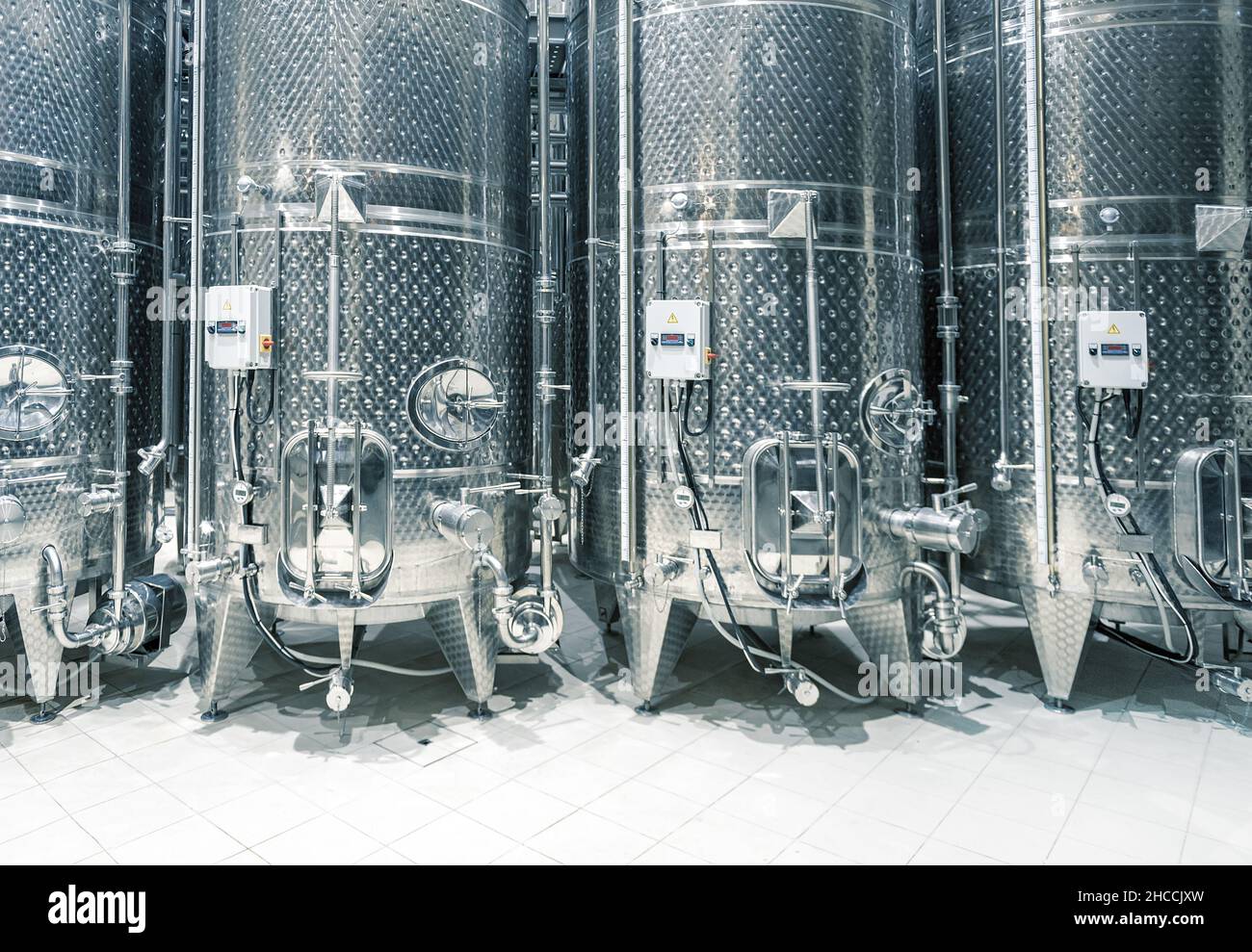 Vasche di fermentazione in acciaio inossidabile in fila in una moderna azienda vinicola Foto Stock