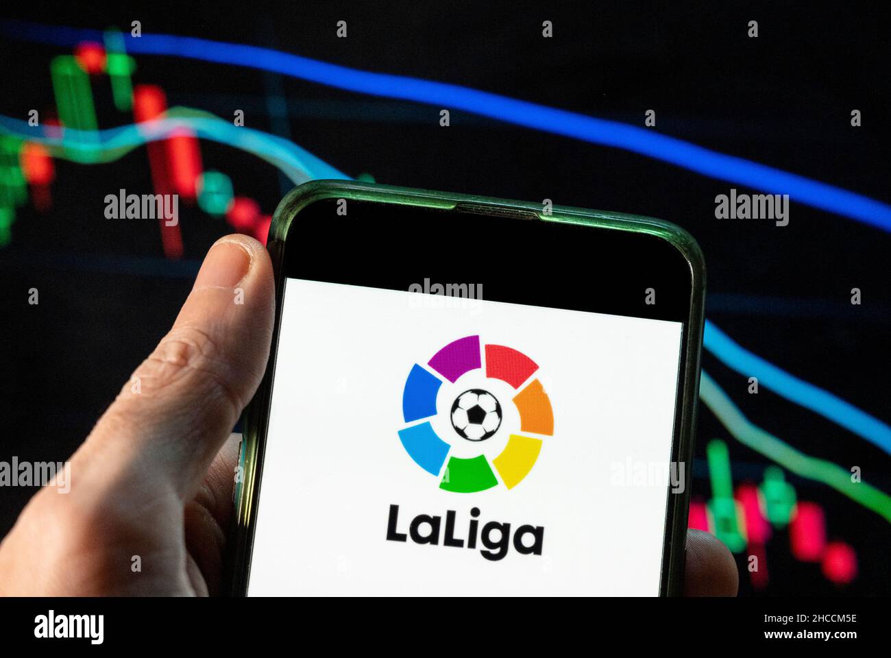 Cina. 4th Dic 2021. In questa foto raffigurante il logo della lega calcistica professionale spagnola LaLiga visto su uno smartphone con un grafico di indice di borsa economica sullo sfondo. (Credit Image: © Budrul Chukrut/SOPA Images via ZUMA Press Wire) Foto Stock