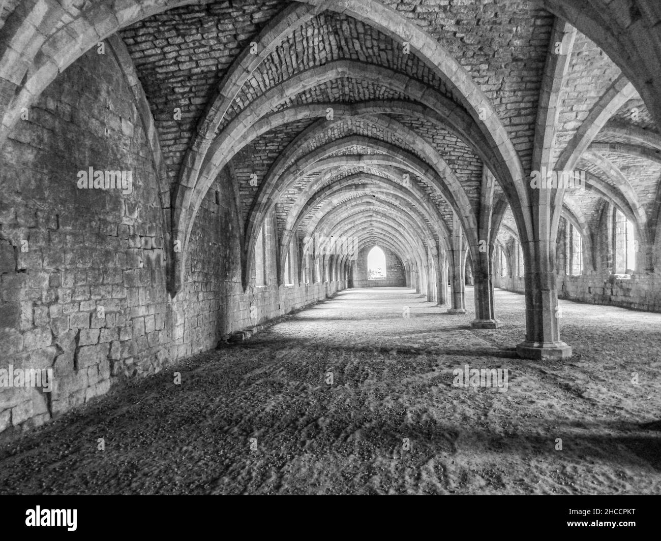 Scala di grigi ripresa all'interno di un vecchio monastero vuoto con architettura gotica Foto Stock