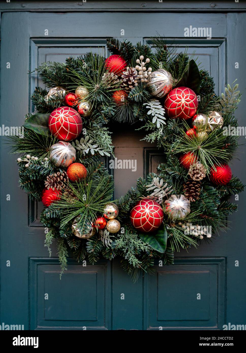 Corona di Natale appesa su una porta d'ingresso Foto Stock