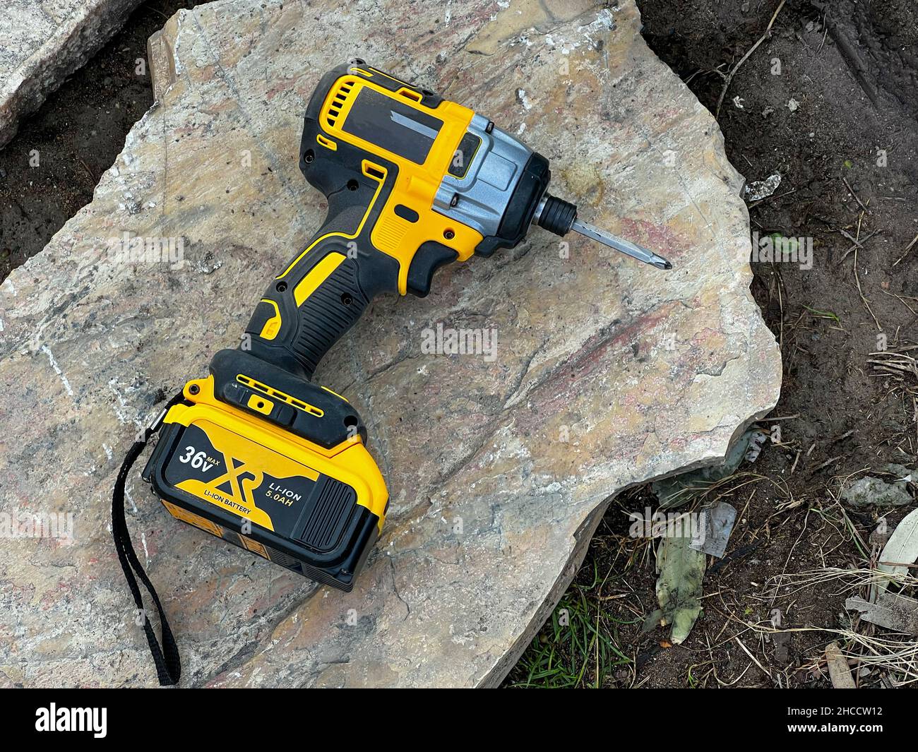 avvitatore a batteria in piedi su roccia a terra in cantiere Foto Stock