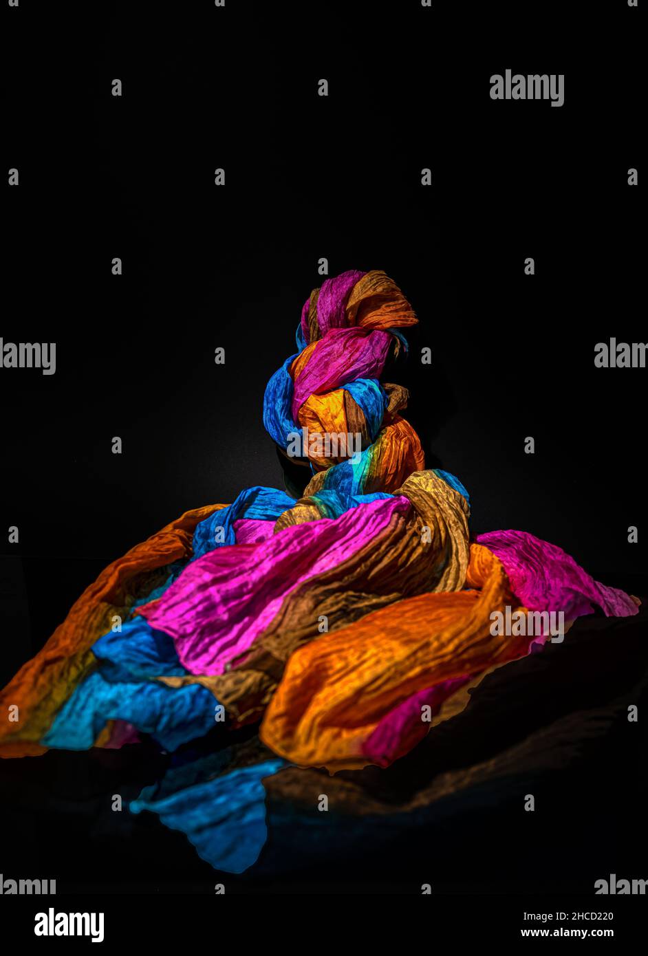 Sciarpa colorata su sfondo nero, pittura chiara Foto Stock