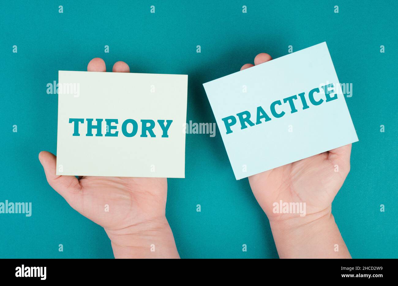 Le parole teoria e pratica sono in piedi su pezzi di carta, concetto di istruzione, imparare facendo Foto Stock