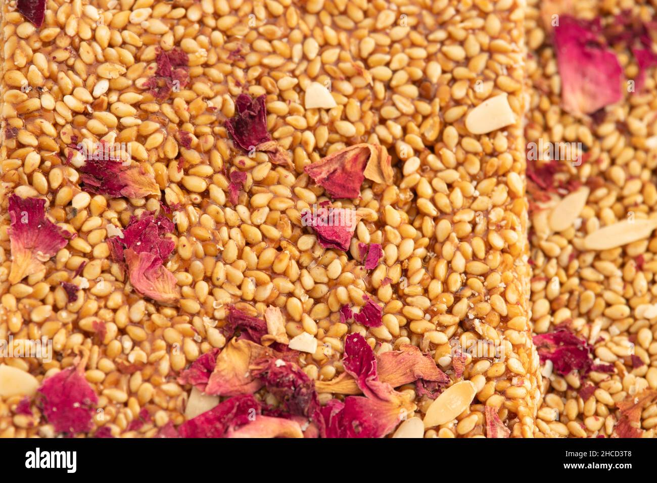 Primo piano di semi di Sesamo Rose Peanut fragole noto come Tilgul Gulab Gud Patti Chikki Mithai, Kozinaki o Gur Papadi fatto di Til, gelso, fiore PET Foto Stock