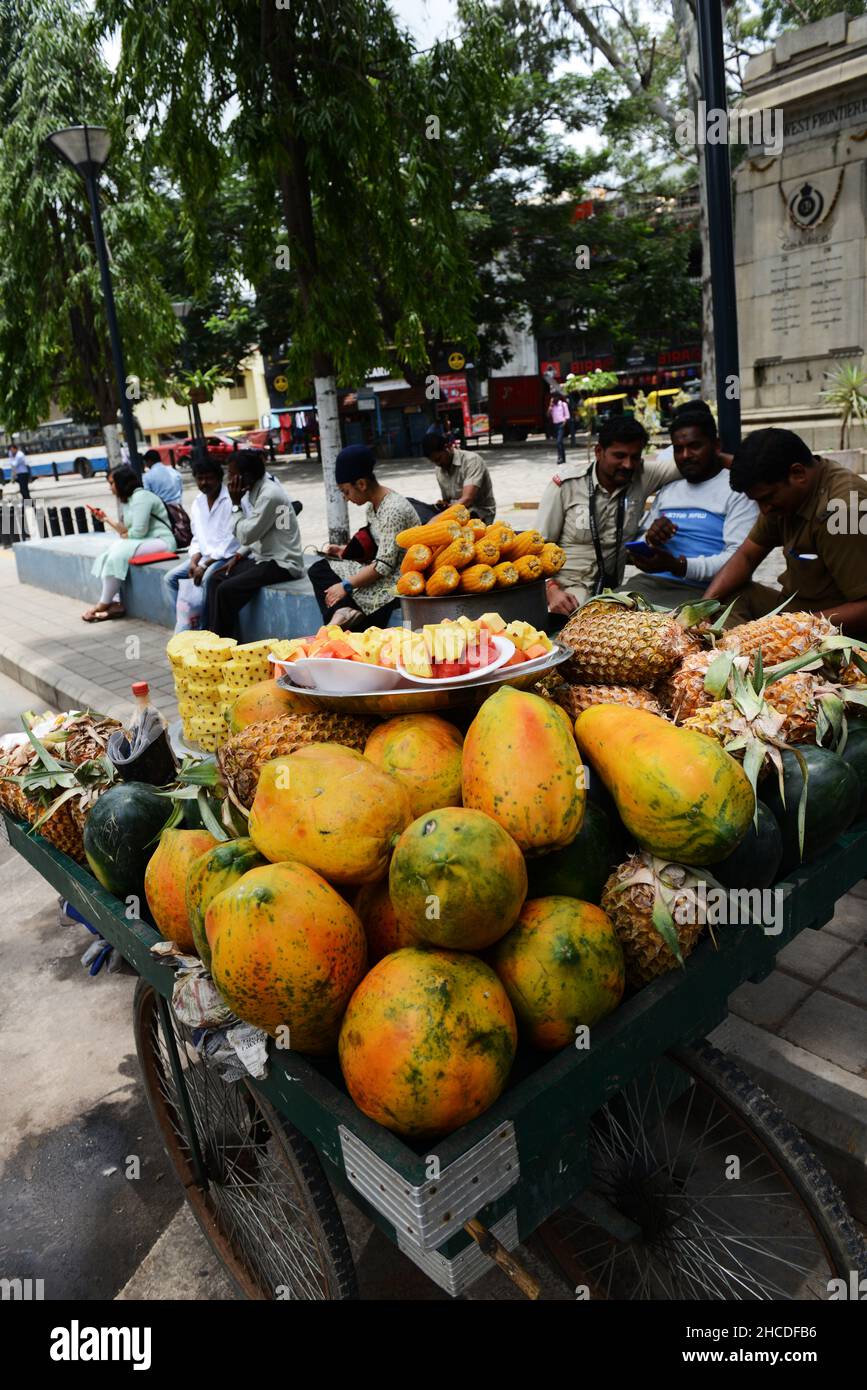 Un fornitore di frutta fresca che vende spuntini di frutta a Bangalore, India. Foto Stock