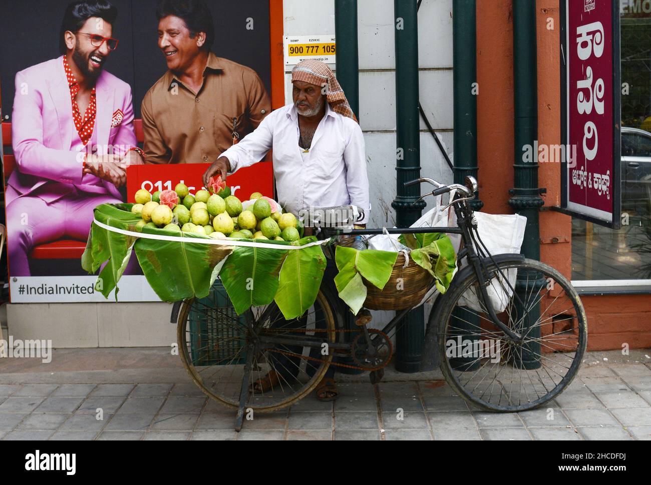 Un fornitore di guava mobile nel centro di Bangalore, India. Foto Stock