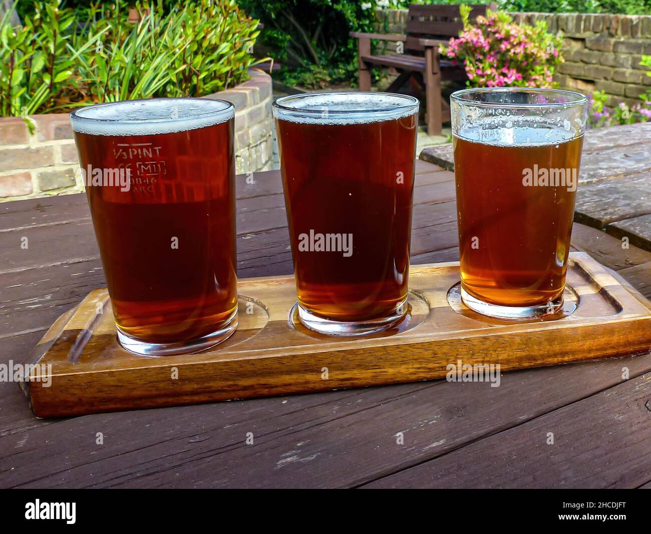 Un primo piano di tre bicchieri di birra fresca su un tavolo di legno in un ristorante Foto Stock