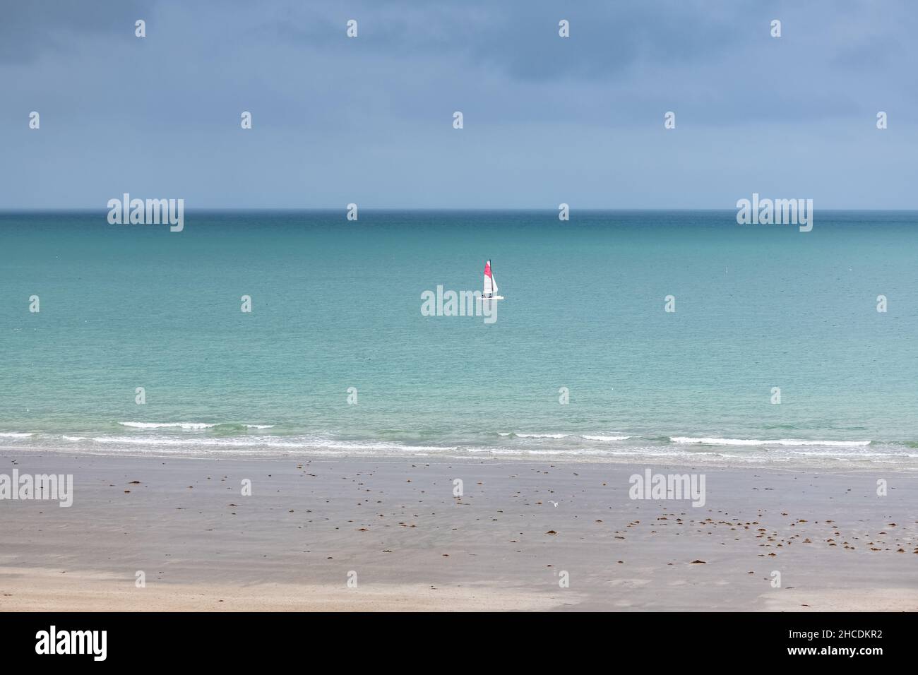 Bella spiaggia a Agon-Coutainville in Normandia, con una barca a vela sul mare Foto Stock
