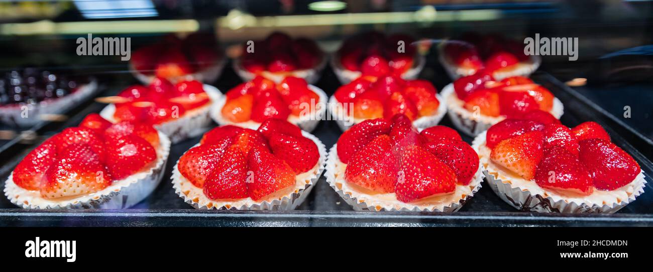 Torta visualizzata nella vetrina di pasticceria o caffè. Pasticceria fresca in mostra su una bancarella di pasticceria presso il famoso mercato Granville a Vancouver Foto Stock