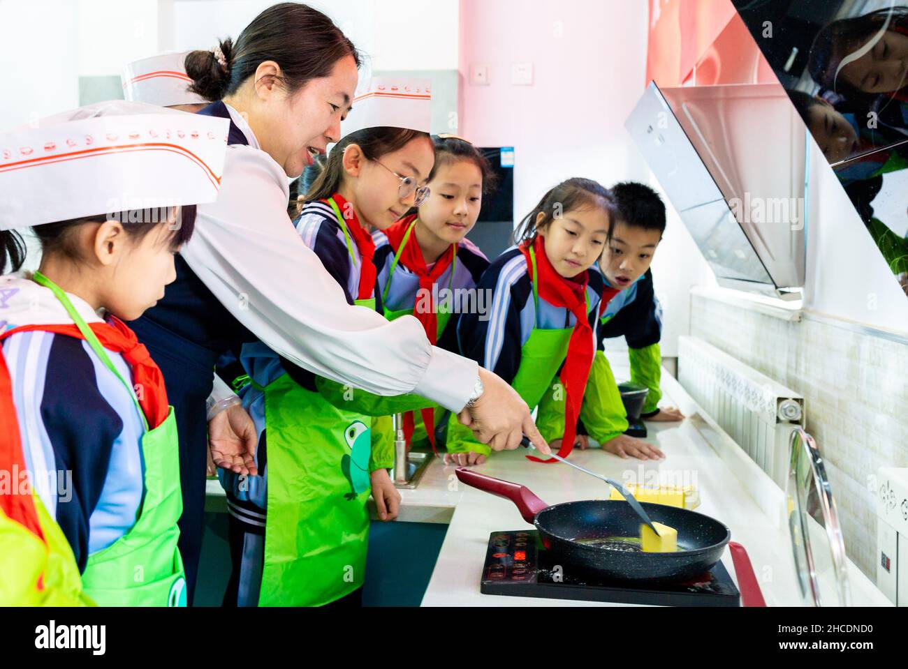 HOHHOT, CINA - 28 DICEMBRE 2021 - gli studenti della scuola elementare imparano a fare caramelle al torrone a Hohhot, nella regione autonoma della Mongolia interna della Cina settentrionale, Foto Stock