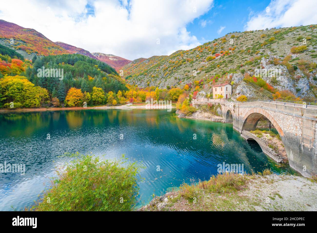Villalago (Abruzzo, Italia) - veduta del borgo medievale in provincia di l'Aquila, nelle gole del Sagittario, con lago di San Domenico, a fogliame Foto Stock